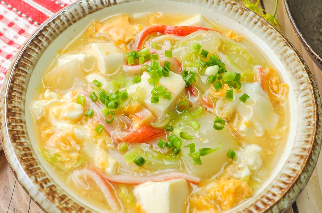 器に盛られた豆腐、カニカマ入りスープ。卵やネギがトッピングされている。