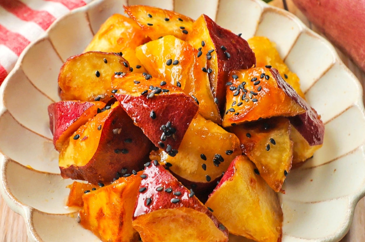 皿に盛られた大学芋。さつまいもがカラメルでコーティングされ、黒ごまが振りかけられている。