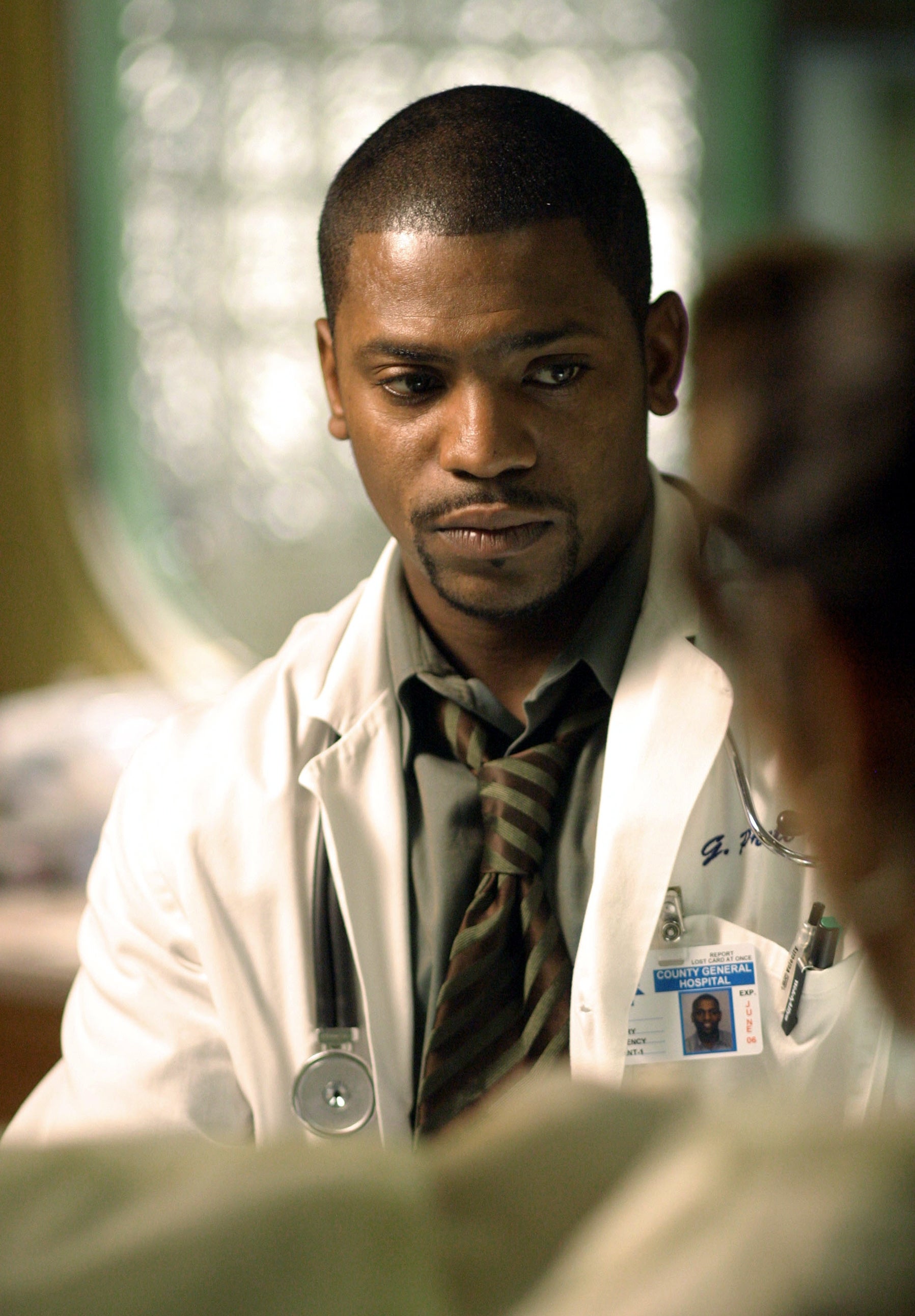 A man wearing a white lab coat and tie