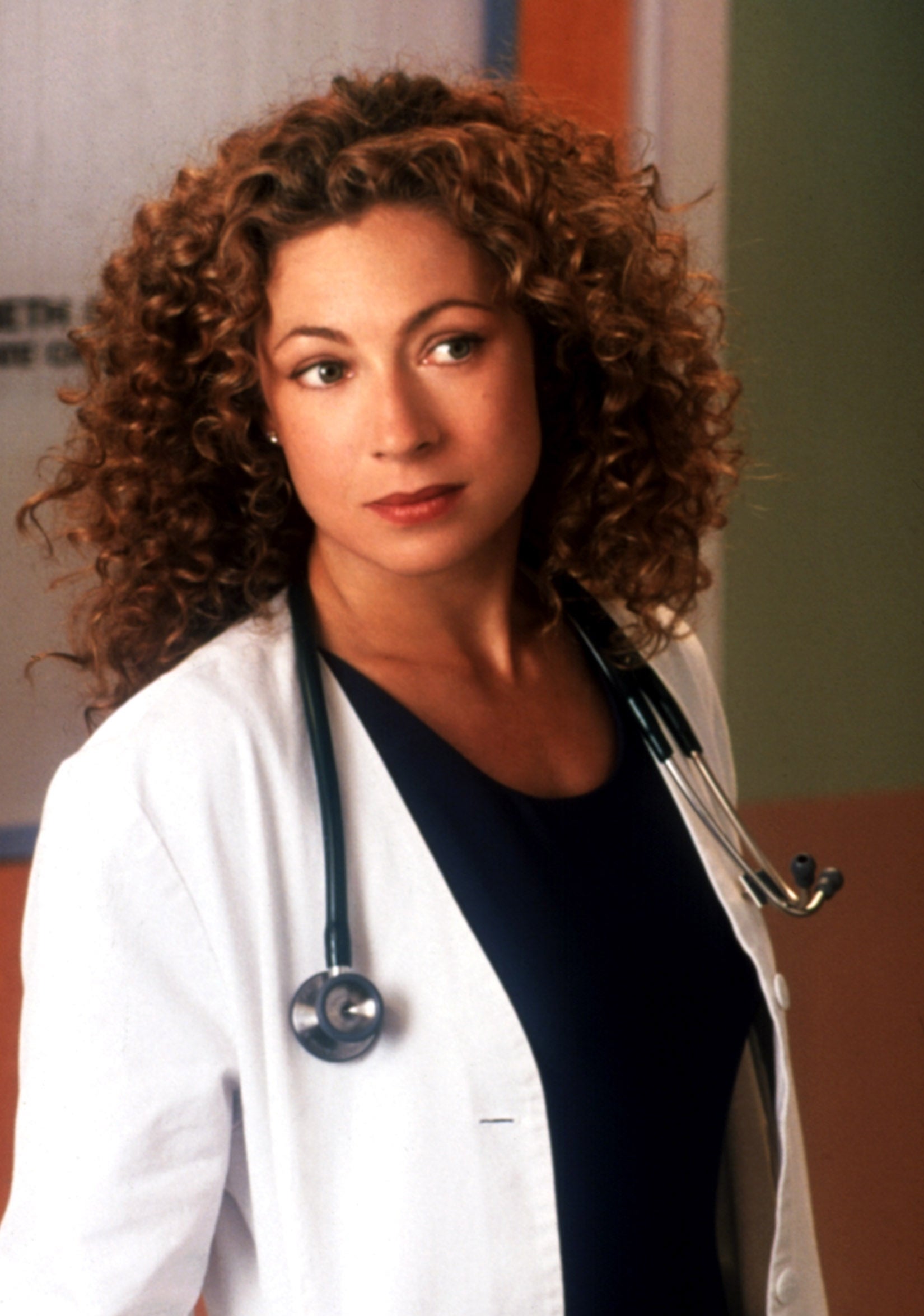 A woman wearing a white lab coat and black shirt