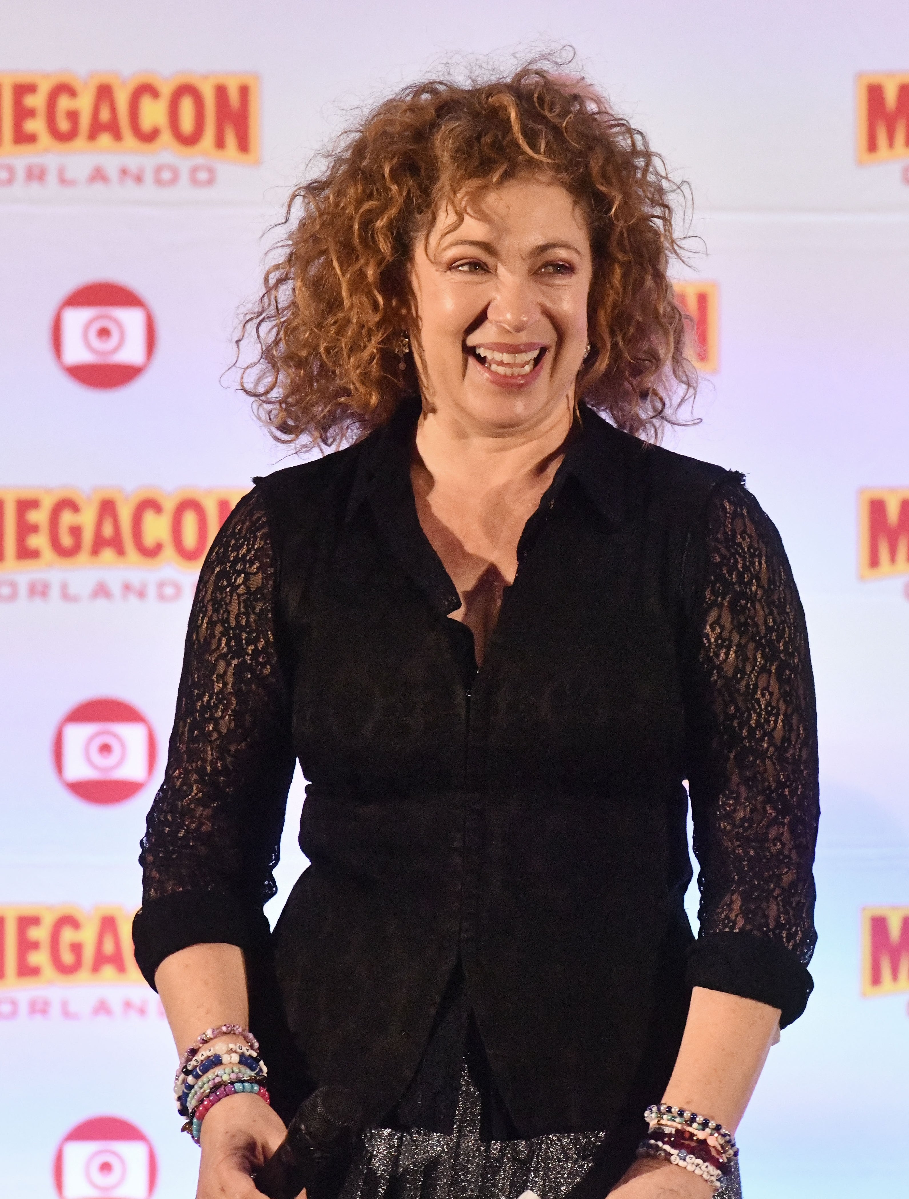 A person wearing a black top with lace sleeves