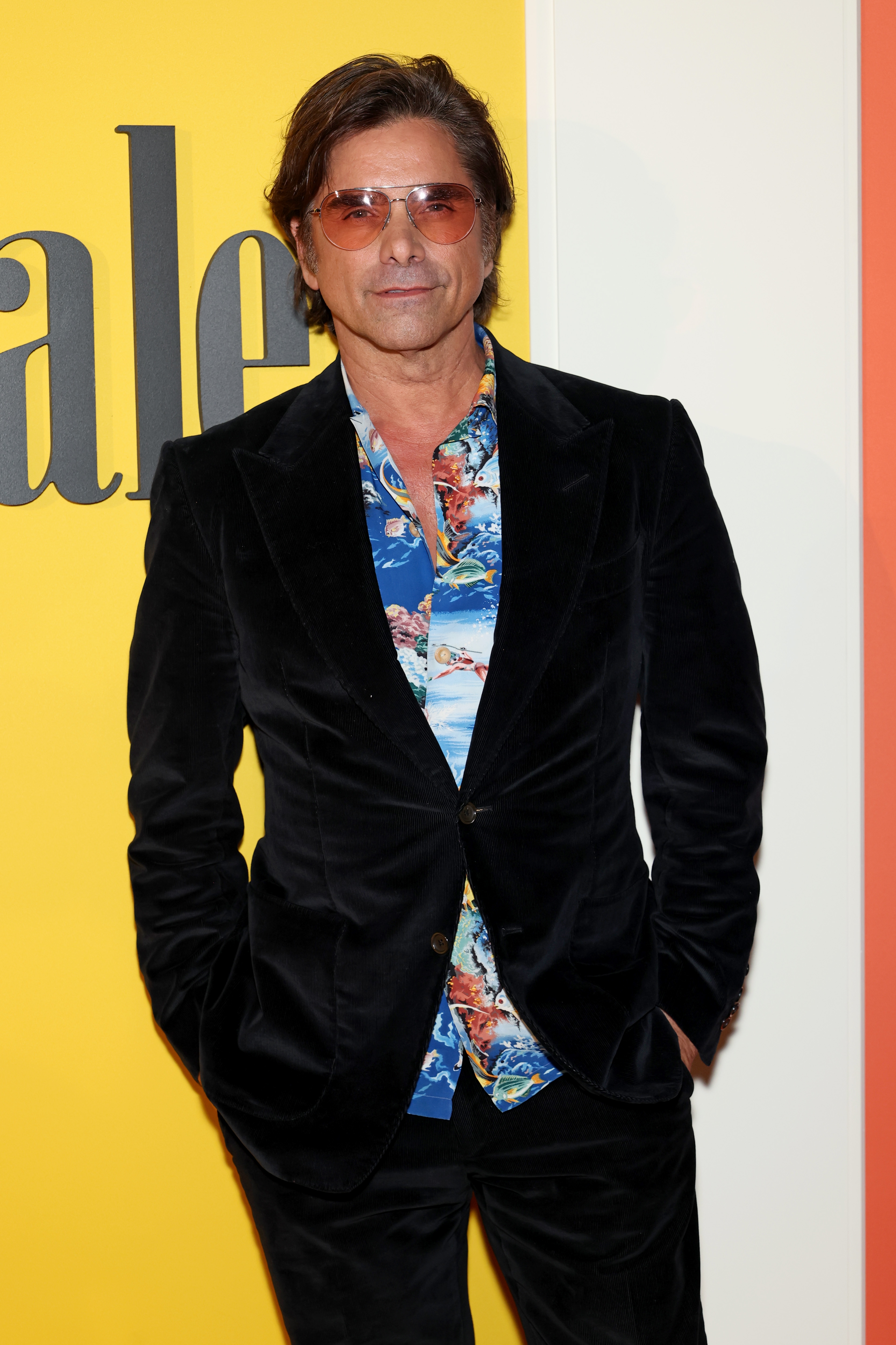 A person wearing a velvet suit and patterned shirt