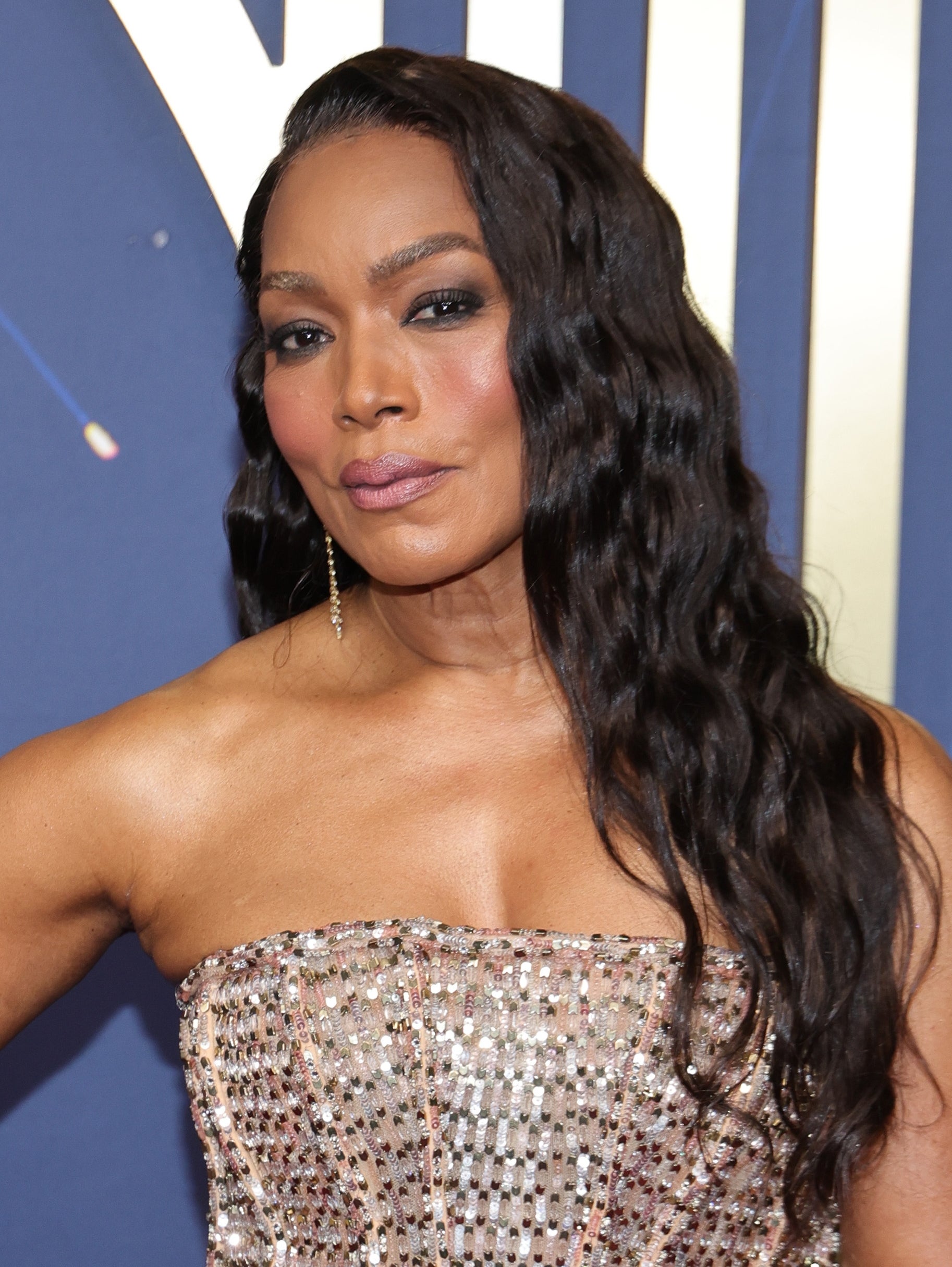 A woman wearing a strapless, sparkly gown