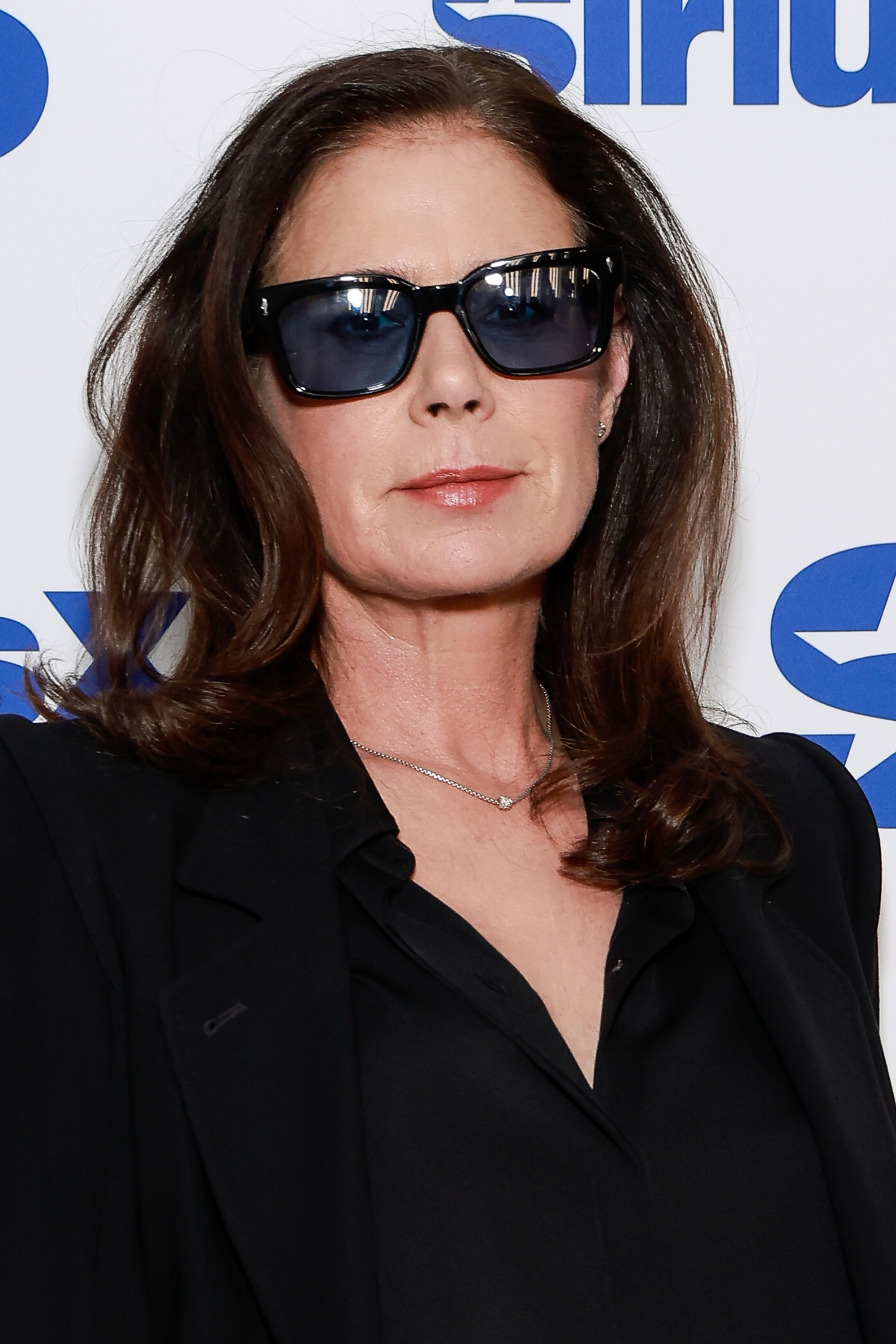 A person wearing sunglasses and a black outfit