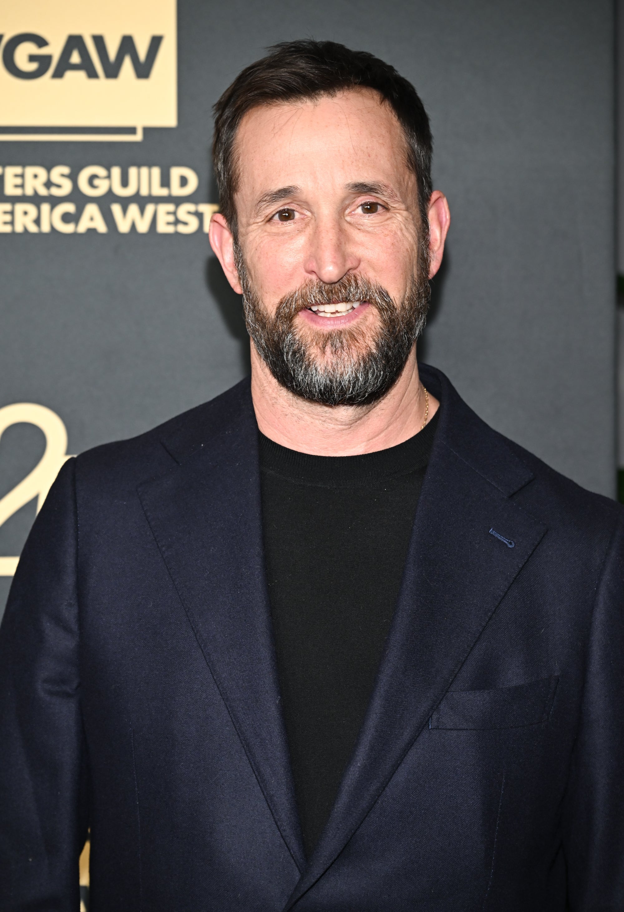 A person in a dark blazer and black shirt