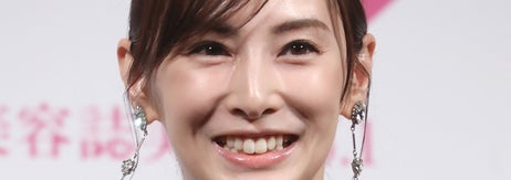 有名人がフォーマルなイベントでスマートなドレスを着用し、笑顔を見せている。