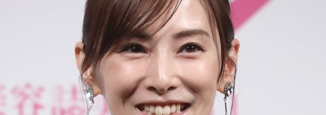 有名人がフォーマルなイベントでスマートなドレスを着用し、笑顔を見せている。