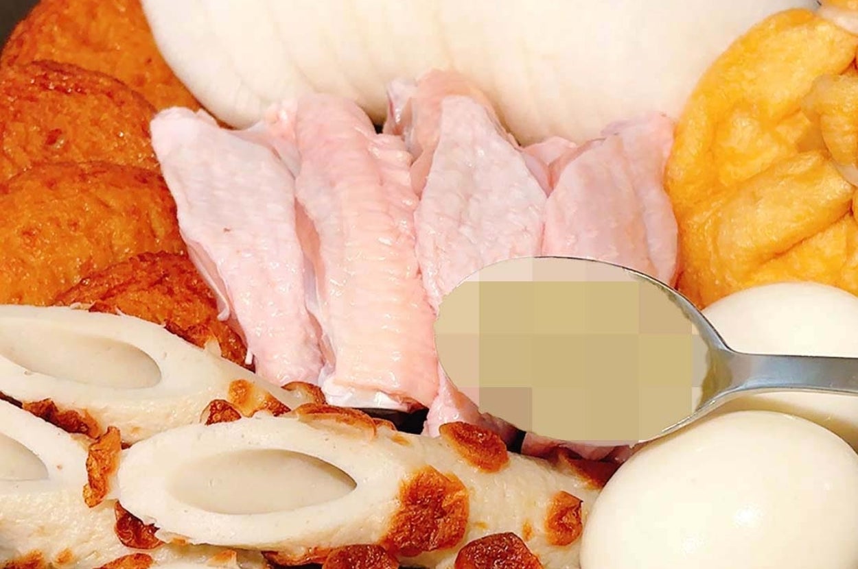 鍋に鶏手羽、かまぼこ、大根、卵、揚げ物が盛り付けられている料理の写真。