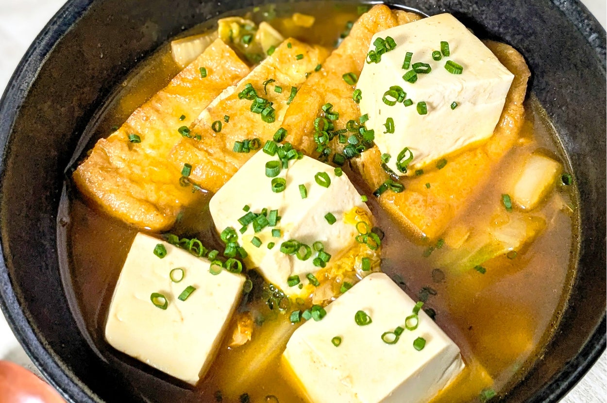 鍋の中には豆腐と油揚げ、ねぎが入った温かい料理。