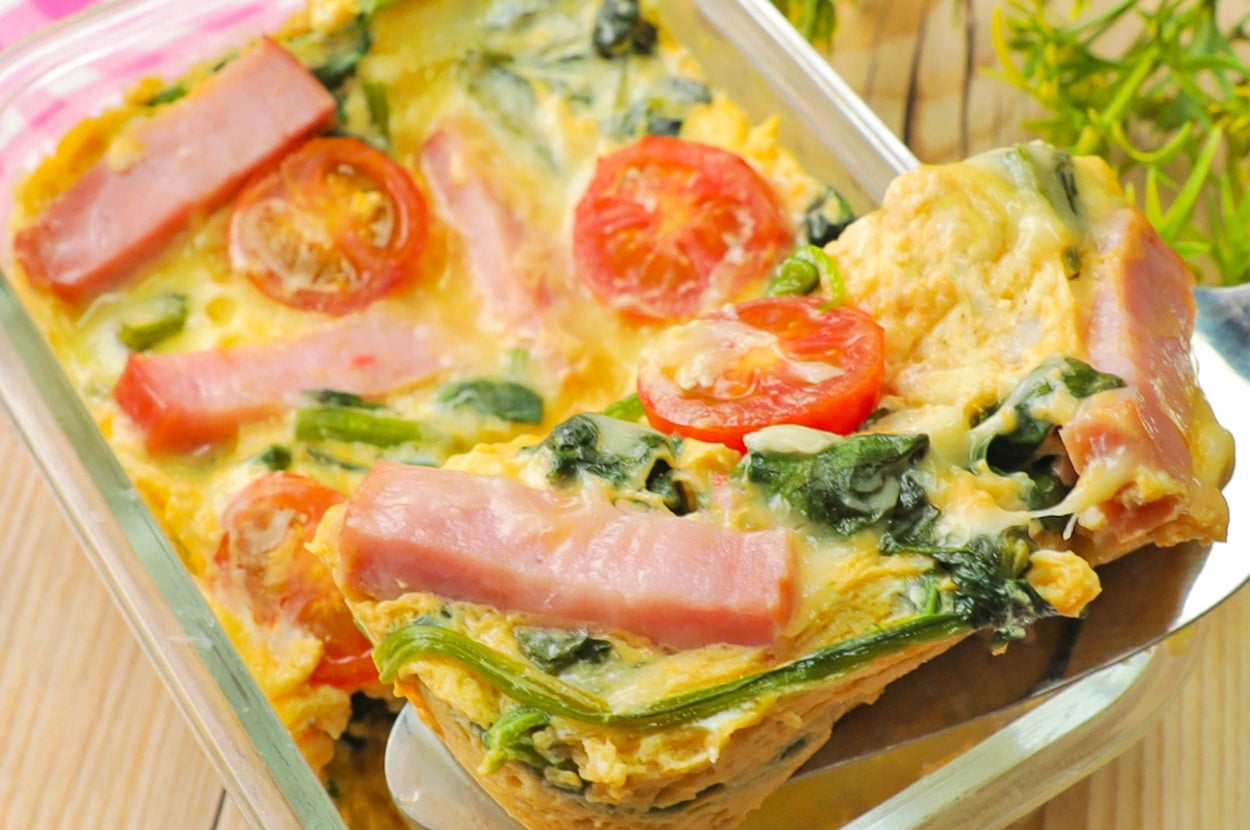 ガラス容器に入ったキッシュ風の料理。ハム、トマト、ほうれん草が具材として見えている。