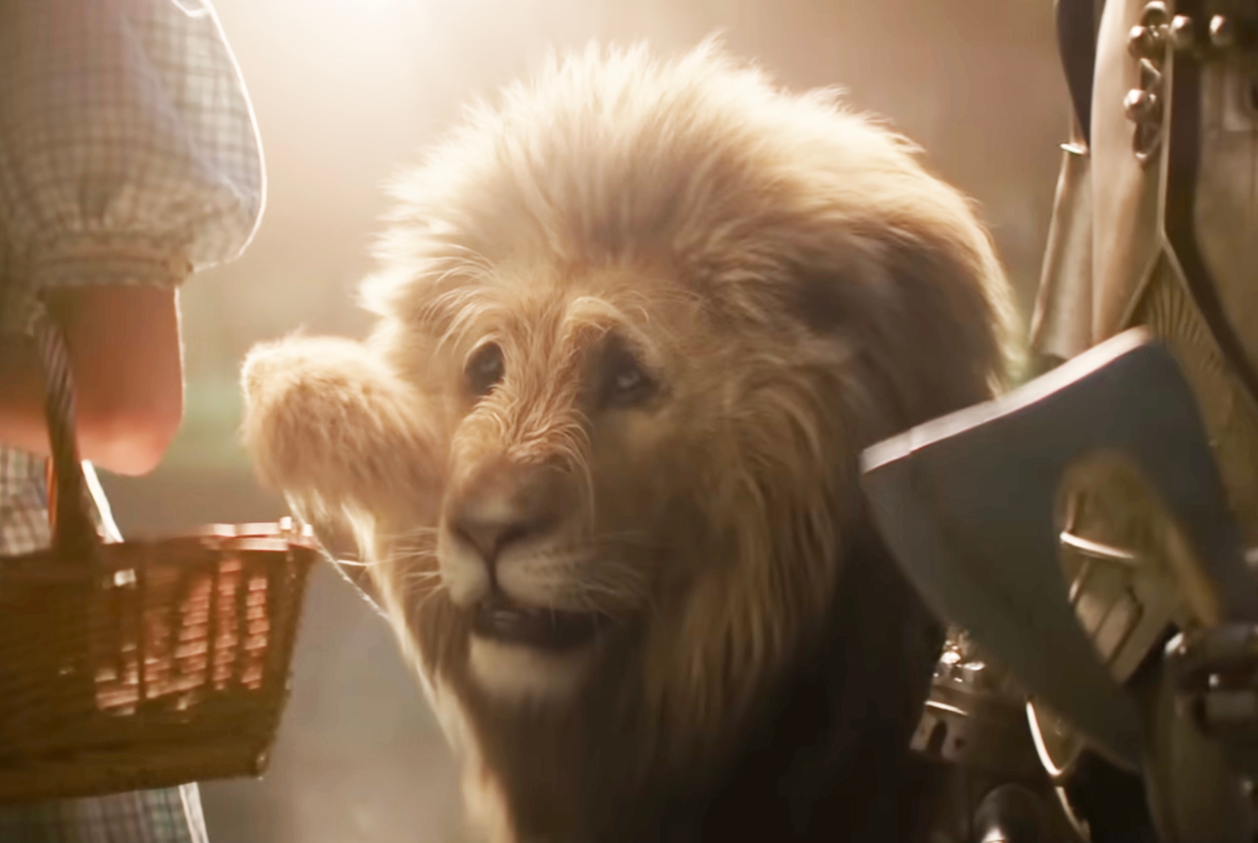 A CGI lion stands next to a person holding a basket, resembling a scene from a fantasy film