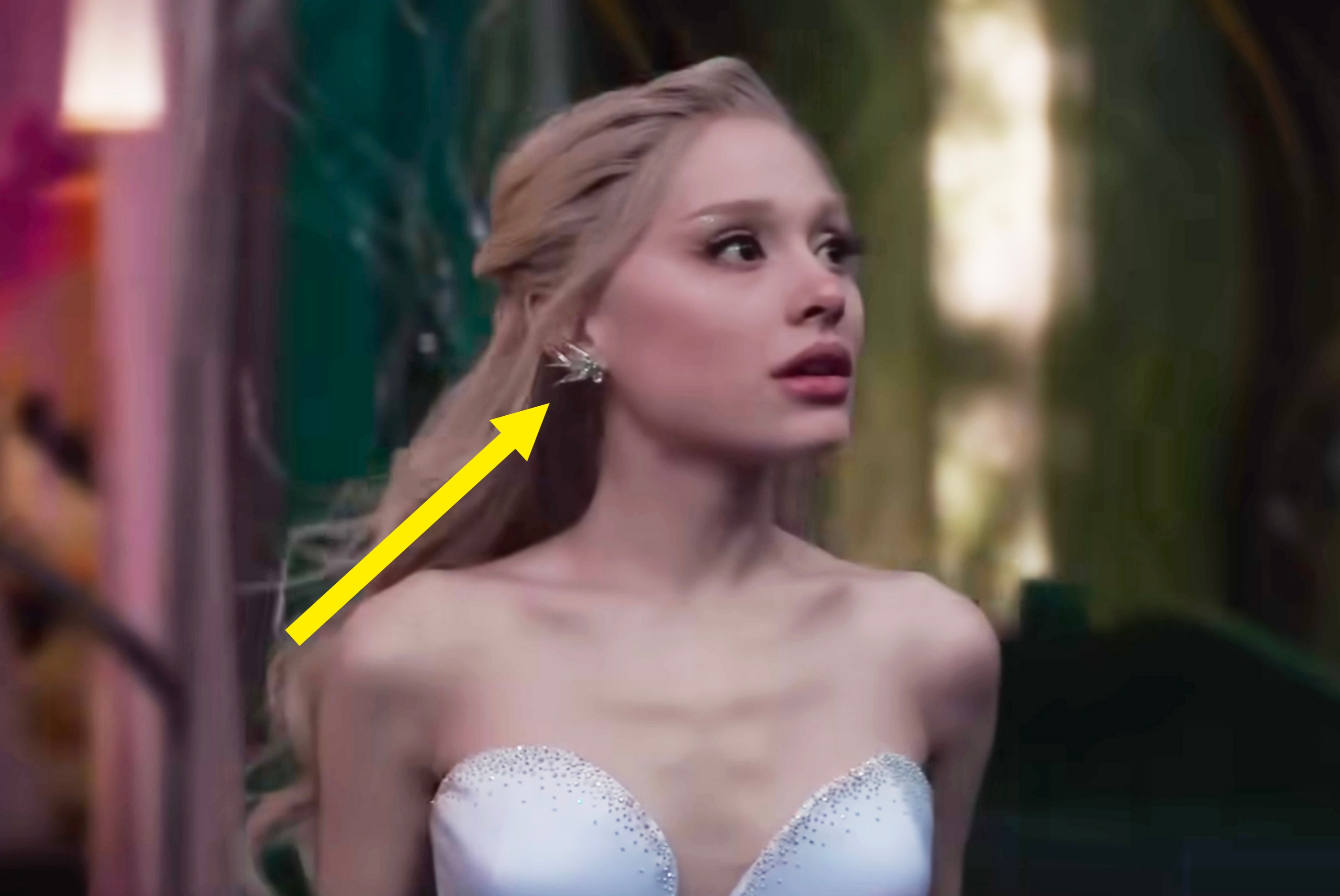 Person in an elegant strapless gown with jeweled details, looking to the side dramatically