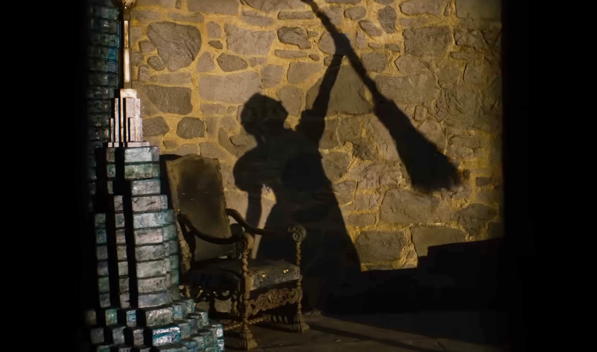 Silhouette of a person holding a broom, casting a dramatic shadow on a stone wall next to an ornate chair, evoking a classic movie scene