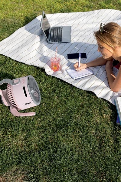 Person lying connected  a picnic blanket, utilizing a laptop and notebook. A portable instrumentality   and portion  are nearby. Suitable for outdoor relaxation oregon  studying