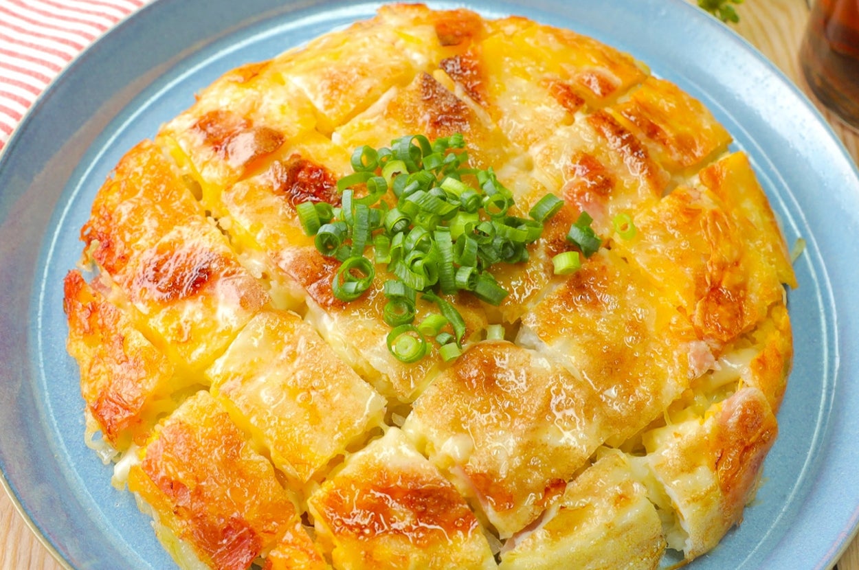 お好み焼き風のじゃがいもとチーズのピザ。刻みネギがトッピングされています。