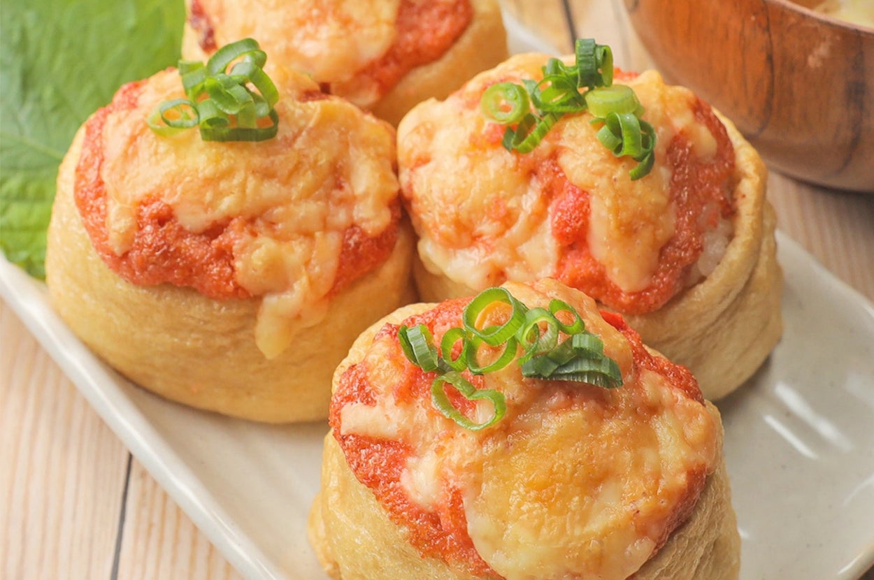 パンにトマトソースとチーズを載せ、ネギをトッピングした焼き料理が皿に盛られている。