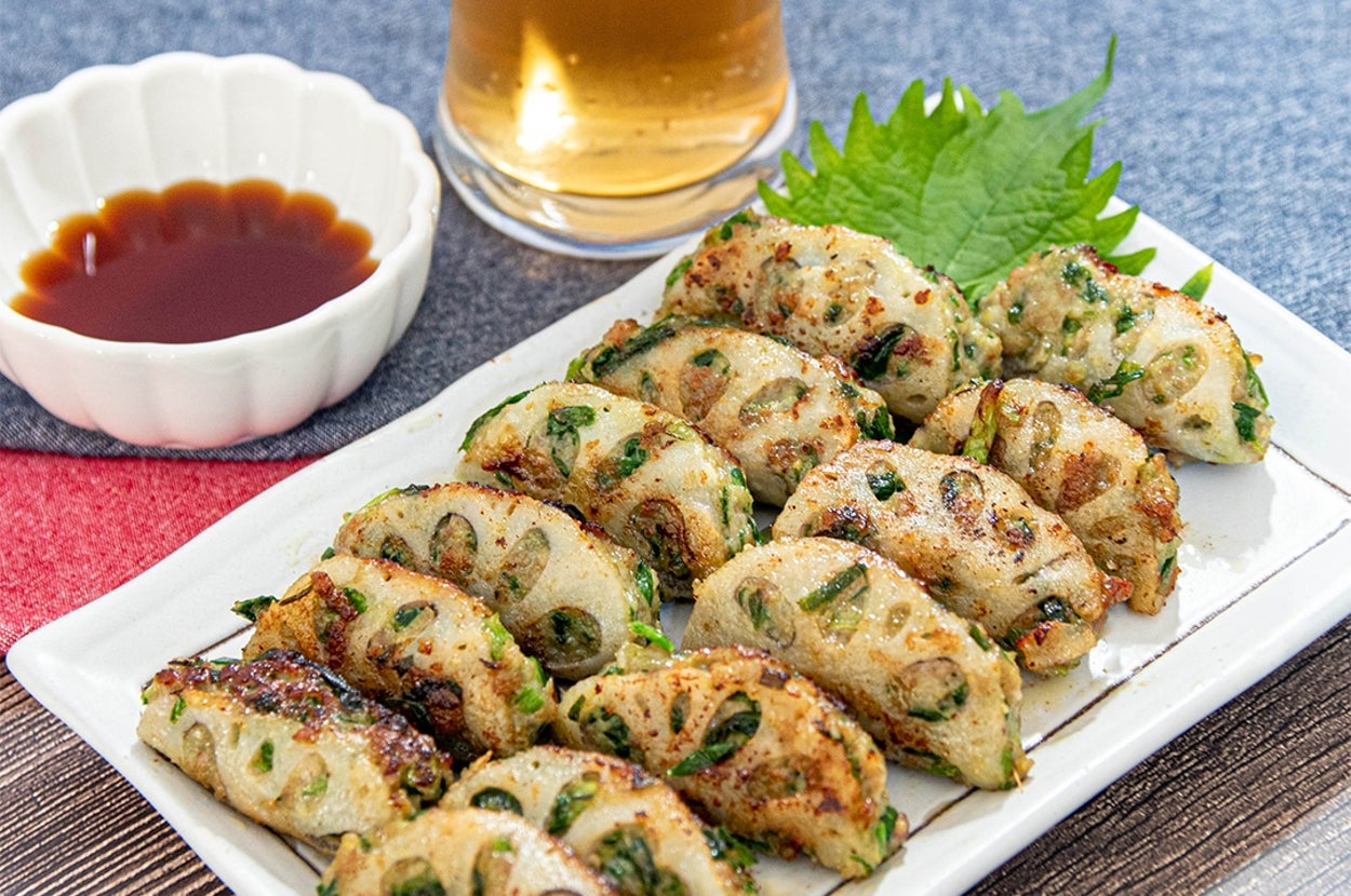 皿に盛られたギョーザ風のれんこん料理とポン酢しょうゆ、ビール入りのグラス。