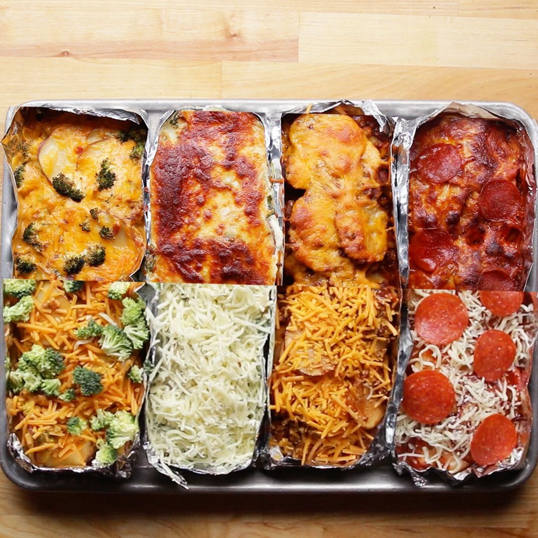 Six different varieties of lasagna in foil sections on a baking tray, including toppings like broccoli, cheese, and pepperoni
