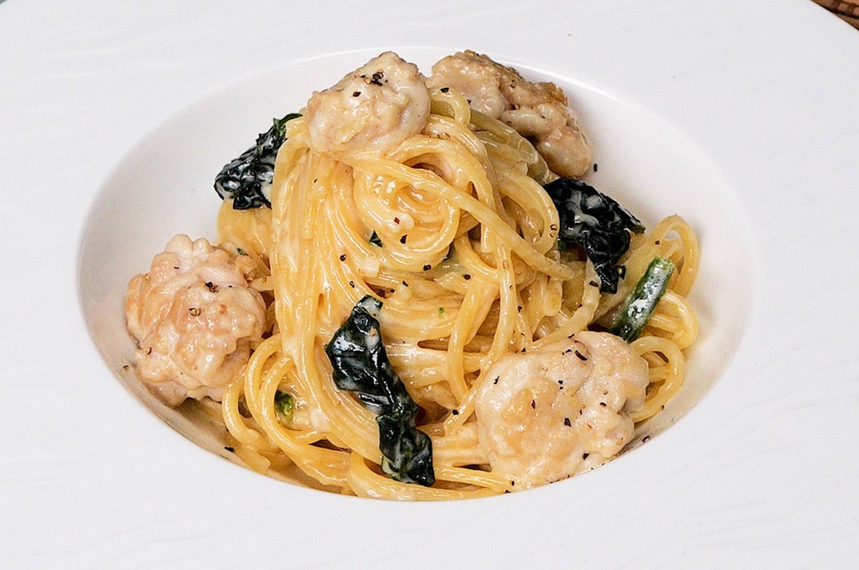 クリーミーなエビとほうれん草のパスタが皿に盛られている。