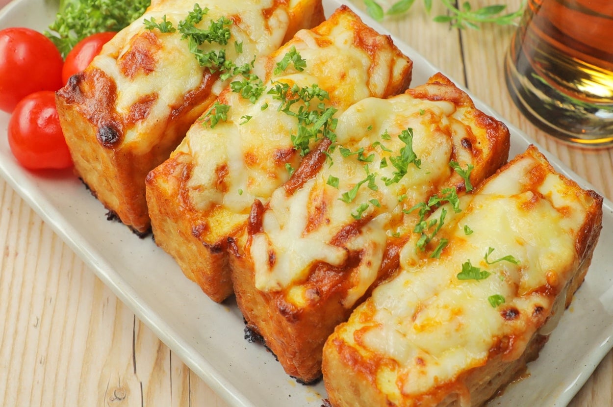 食パンのチーズトースト4枚、トマトとパセリを添えた料理の上からの視点。