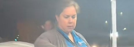 テーブルに並んだ料理の横で人が大きなボトルを持って立っています。テーブルにはライムやソースが入った容器があります。