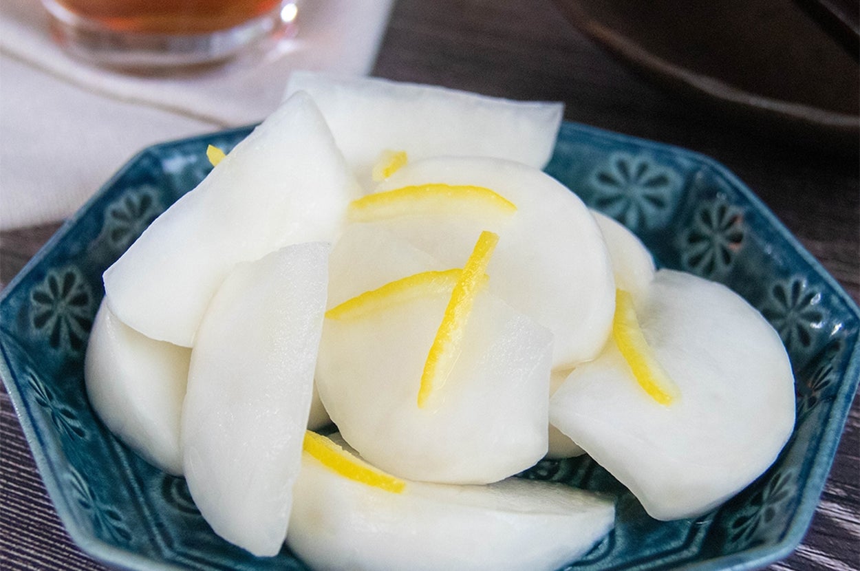 青い皿に盛られたかぶのレモン漬け。