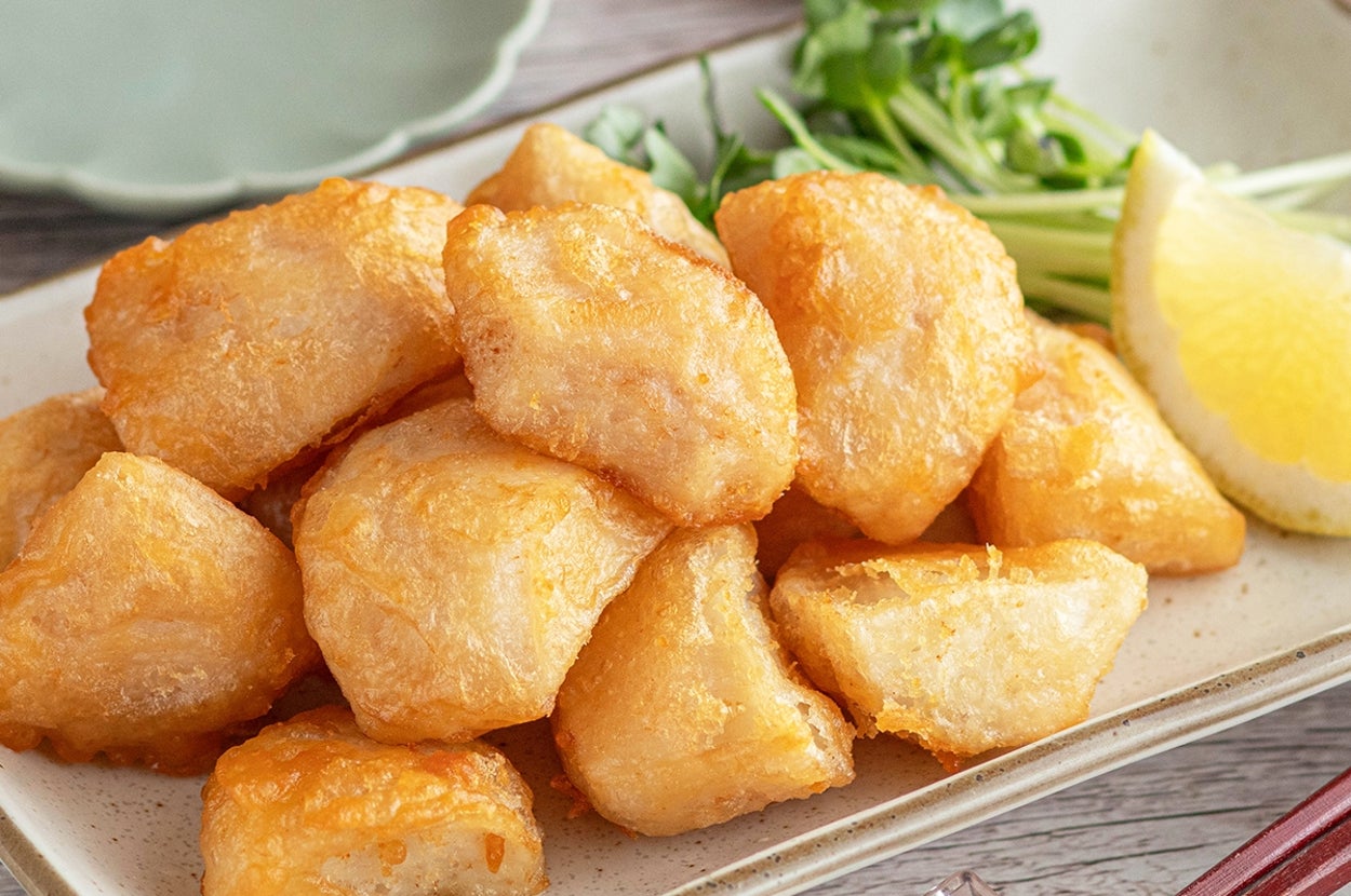 皿に盛られた揚げたての天ぷらとカットレモン、付け合わせの野菜。