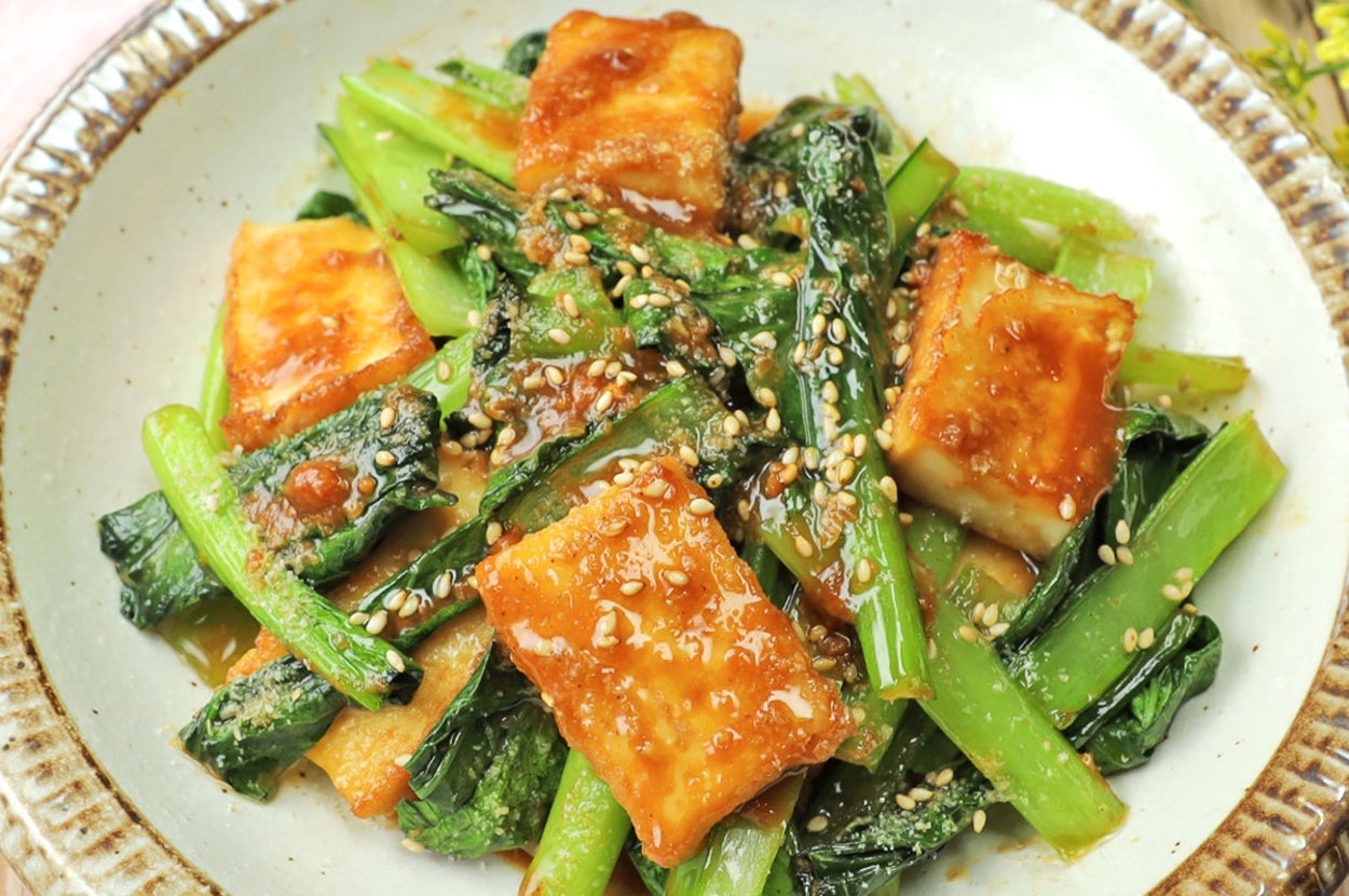 皿に盛られた焼き豆腐と青菜、ゴマがトッピングされた料理。