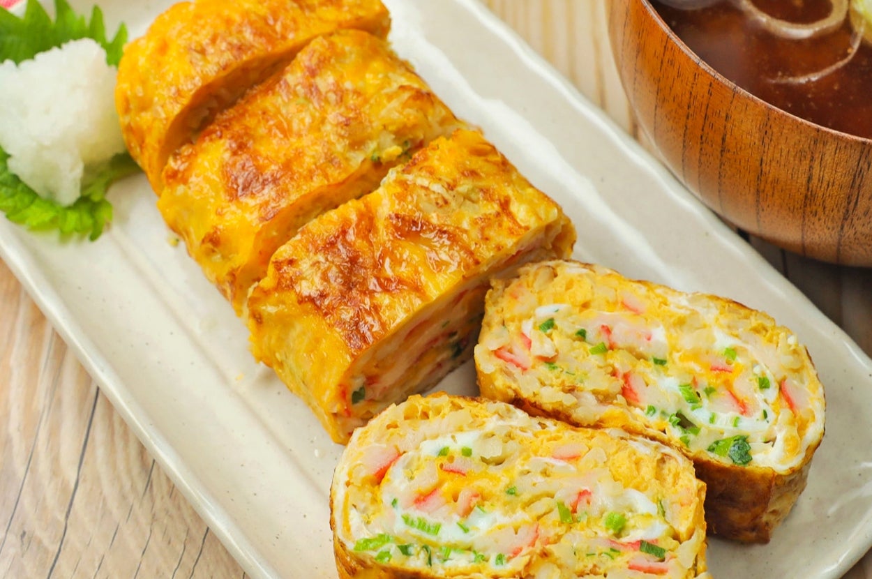 卵焼きに似た料理のスライスが皿に盛り付けられ、味噌汁と共に置かれています。