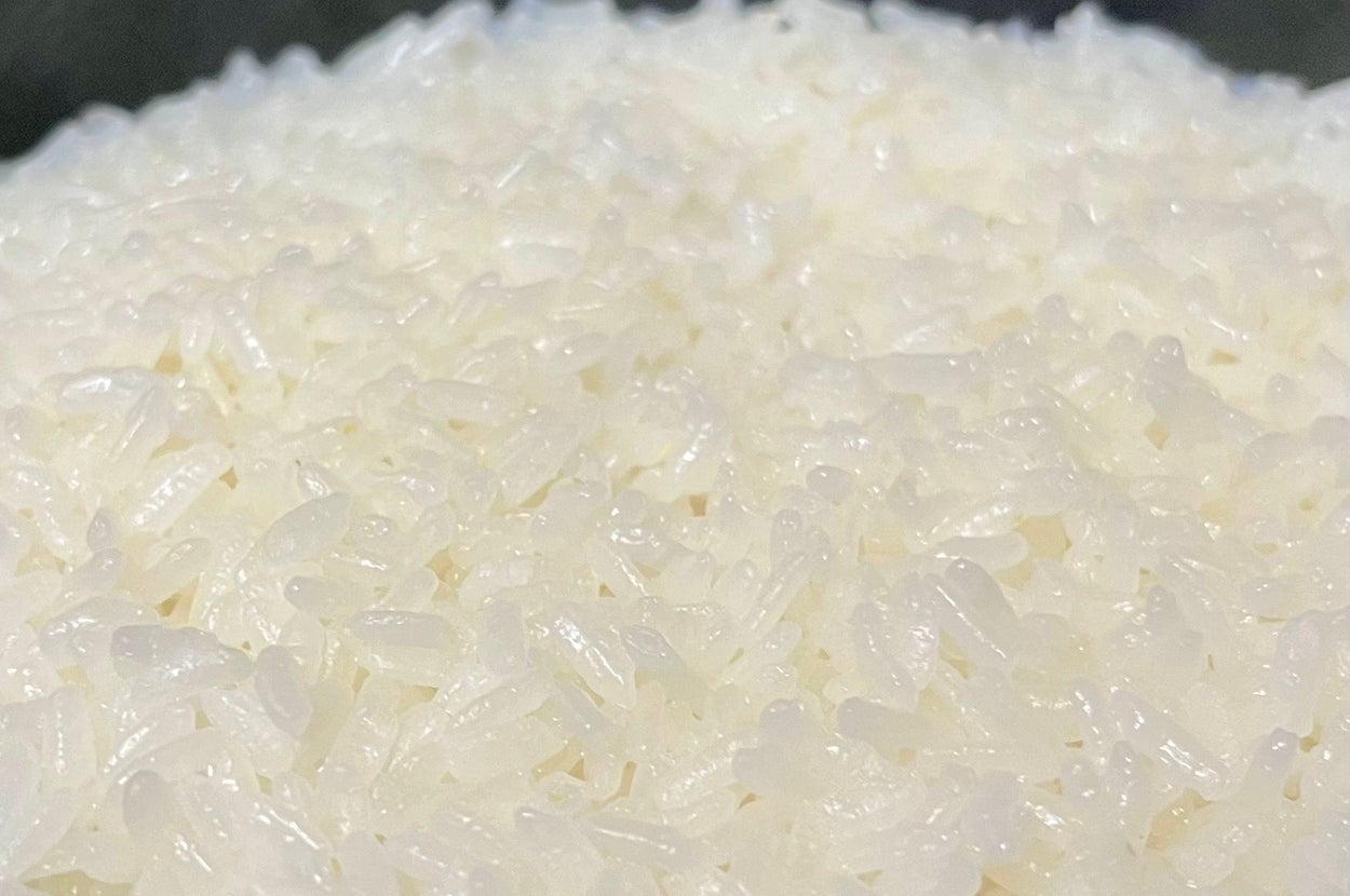 炊き立ての白米のクローズアップ画像。炊飯器またはボウルに盛られ、光沢がありふっくらして見える。