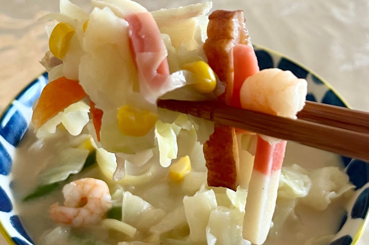 箸で持ち上げられたちゃんぽんの一部が、野菜やシーフードと共に映っている。