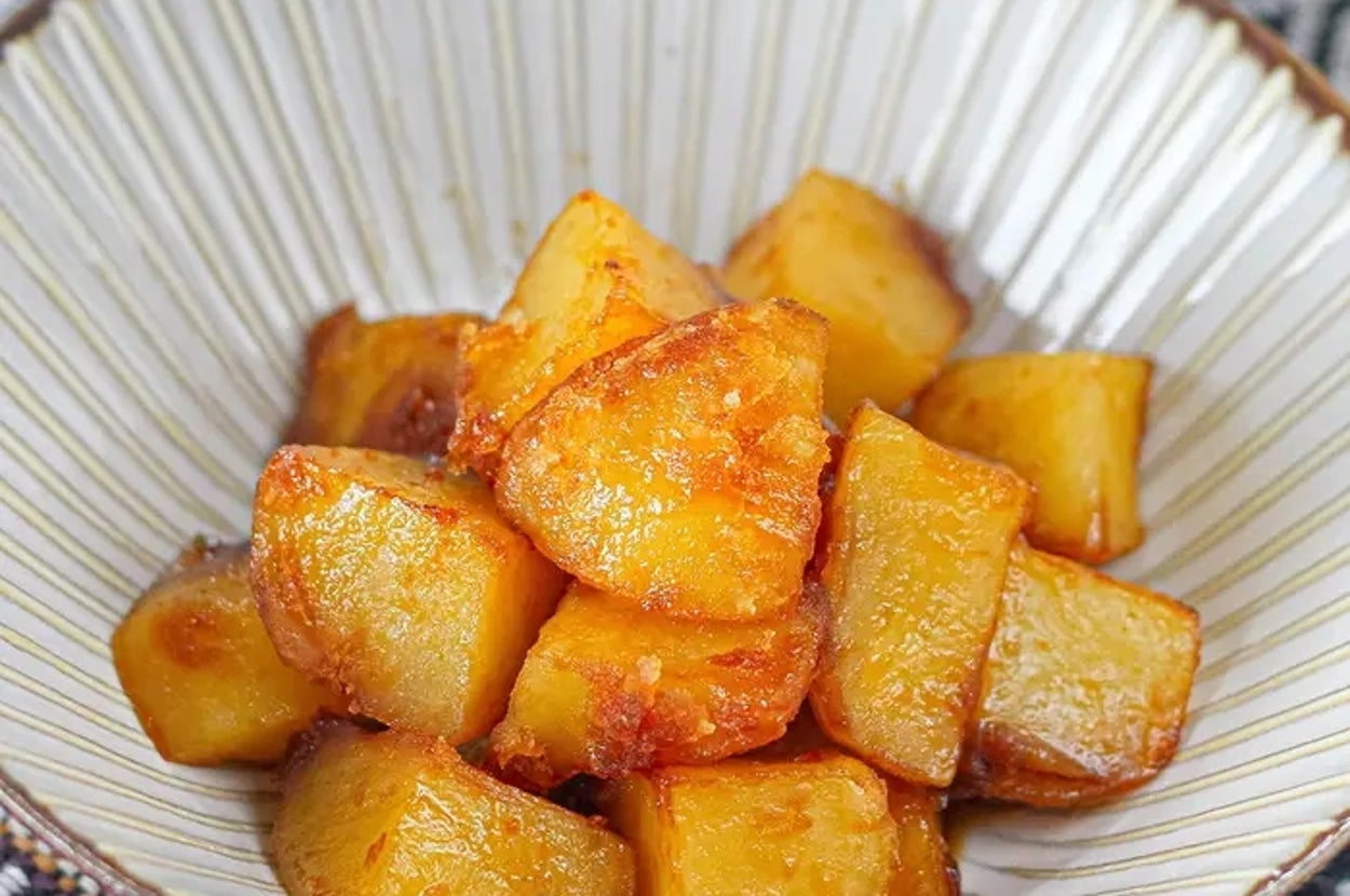 お皿に盛られたカリッと焼かれた角切りポテト。シンプルでおいしそうな料理。