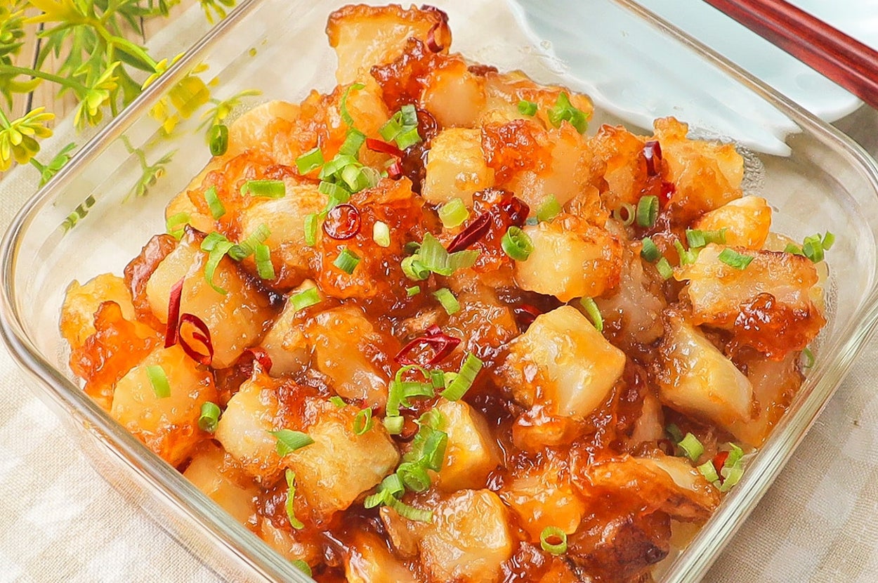 ガラスの器に入った彩り豊かな炒めポテト、ネギと唐辛子がトッピングされている。