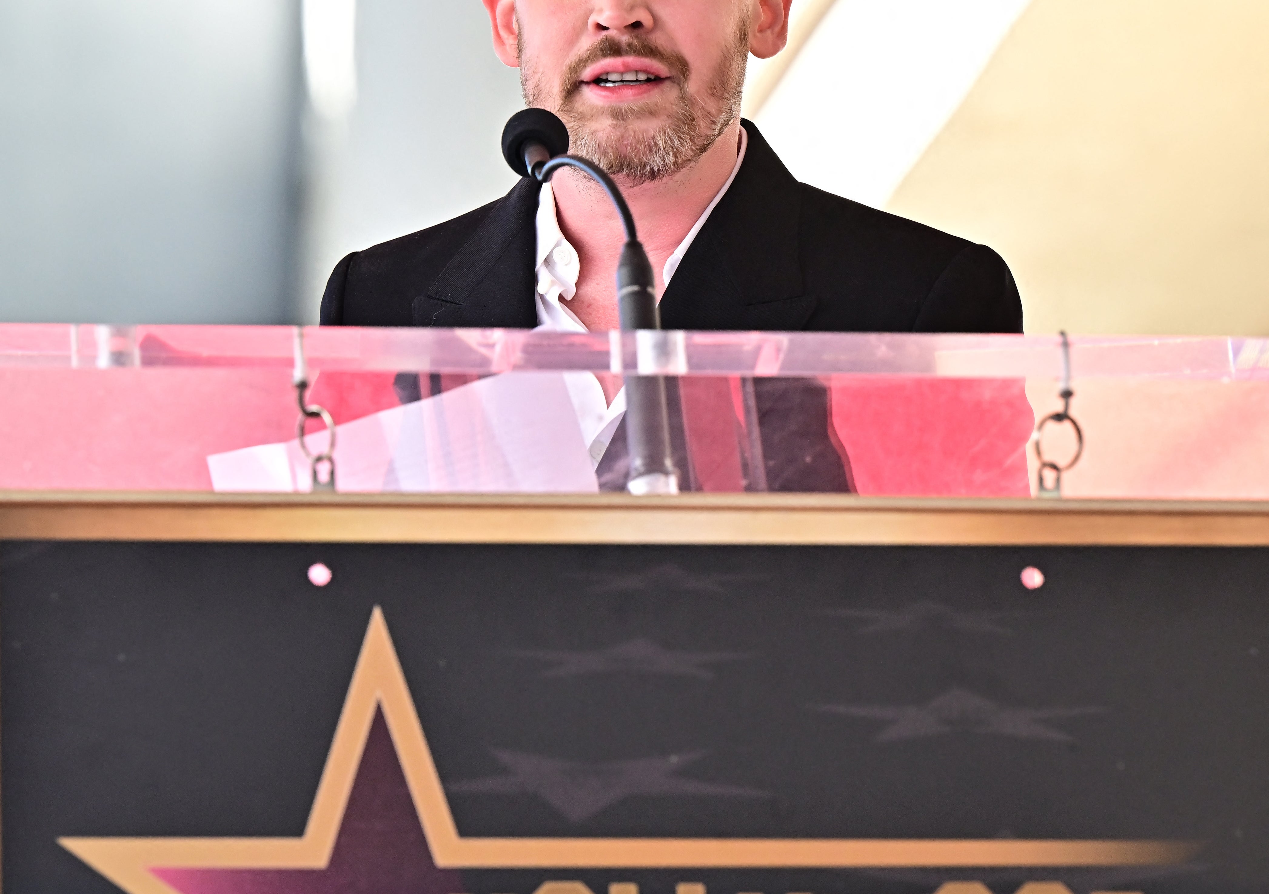Macaulay Culkin successful  a suit   speaking astatine  a podium for the Hollywood Walk of Fame