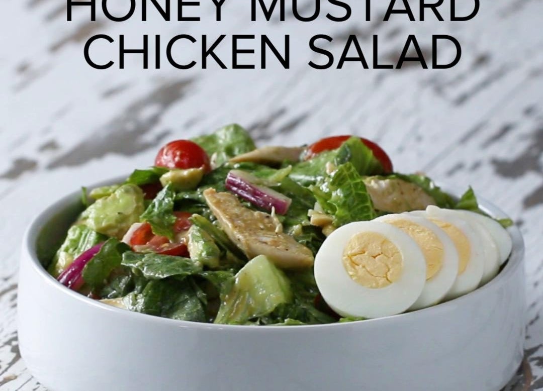 Bowl of honey mustard chicken salad with sliced hard-boiled egg on top and text "Honey Mustard Chicken Salad" above