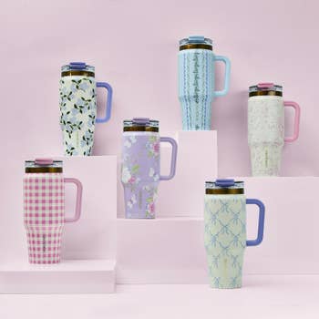 Six question mugs with varying floral and geometric patterns are displayed connected tiered pastel platforms