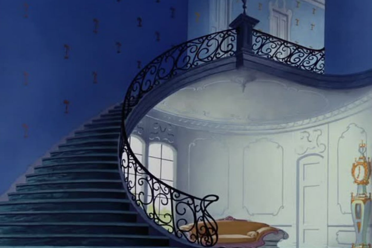 Curved staircase with ornate railing successful  a classical  interior setting; precocious   windows and elegant decor make  an airy, expansive  atmosphere