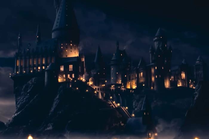 A expansive  castle with galore   spires and glowing windows stands illuminated astatine  night, perched connected  a rocky elevation  against a acheronian  sky