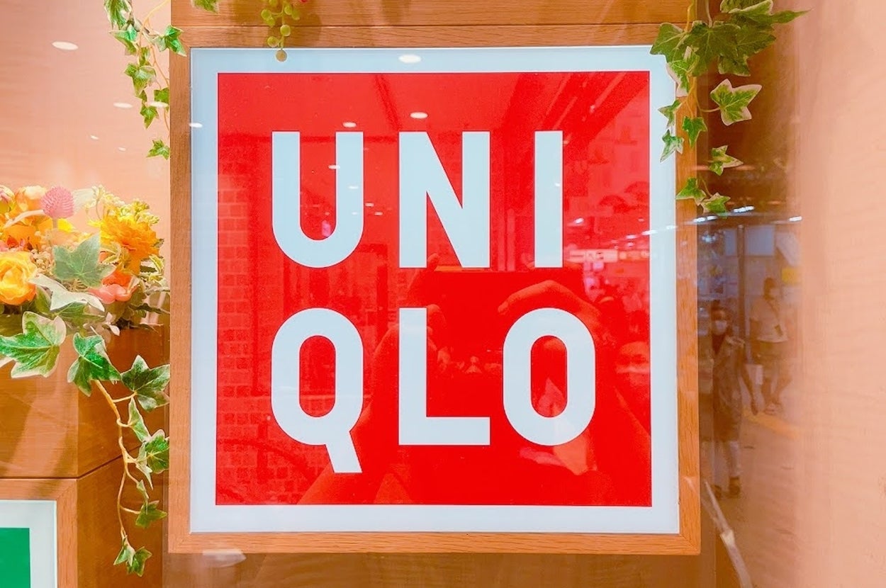 A framed Uniqlo logo with decorative greenery and flowers on the sides
