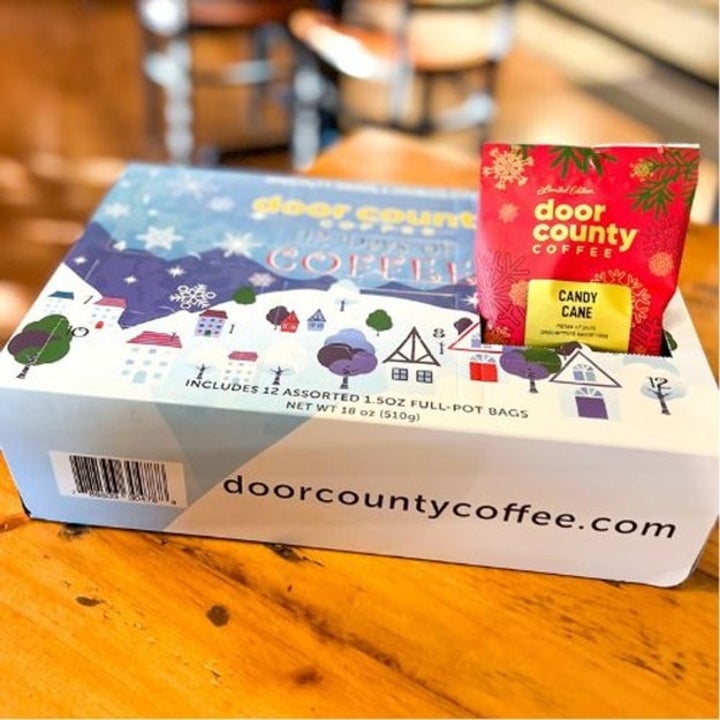 Box of Door County Coffee with a Candy Cane Coffee packet, featuring a festive village design