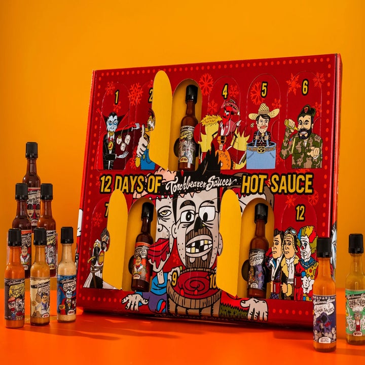 Hot sauce gift set labeled "12 Days of Torture Sauces" featuring cartoon characters and bottles. Additional hot sauce bottles displayed beside the set