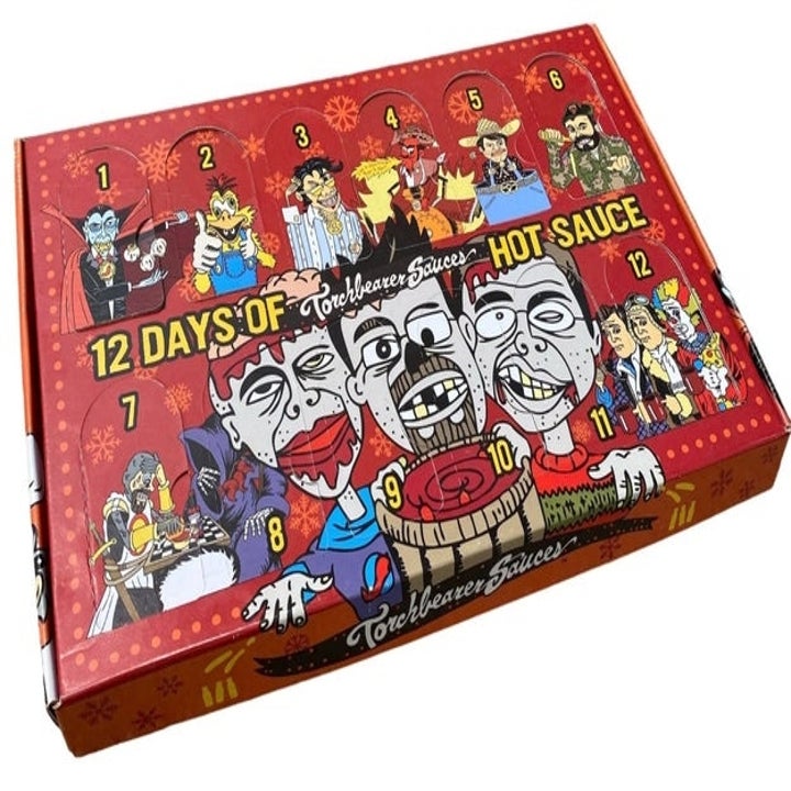 Box labeled "12 Days of Hot Sauce" by Torchbearer Sauces, featuring cartoon characters and a numbered advent calendar design