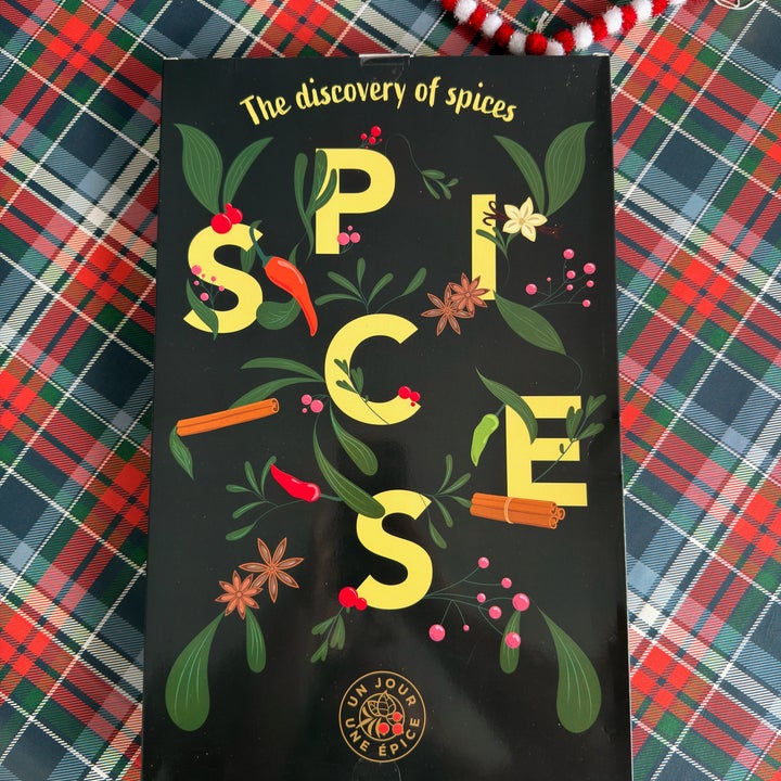 Book titled "The Discovery of Spices" with colorful illustrations of spices and herbs on a checkered tablecloth