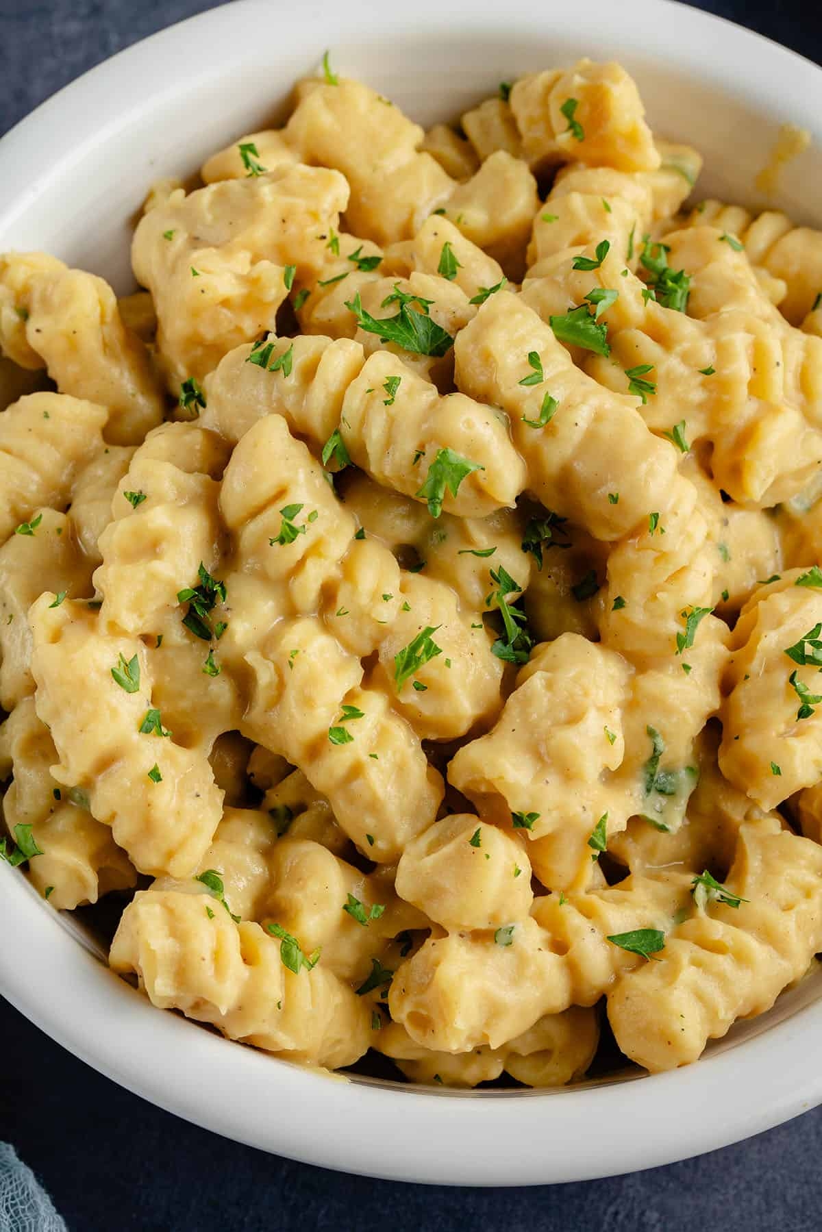 A bowl of creamy gnocchi topped with chopped parsley