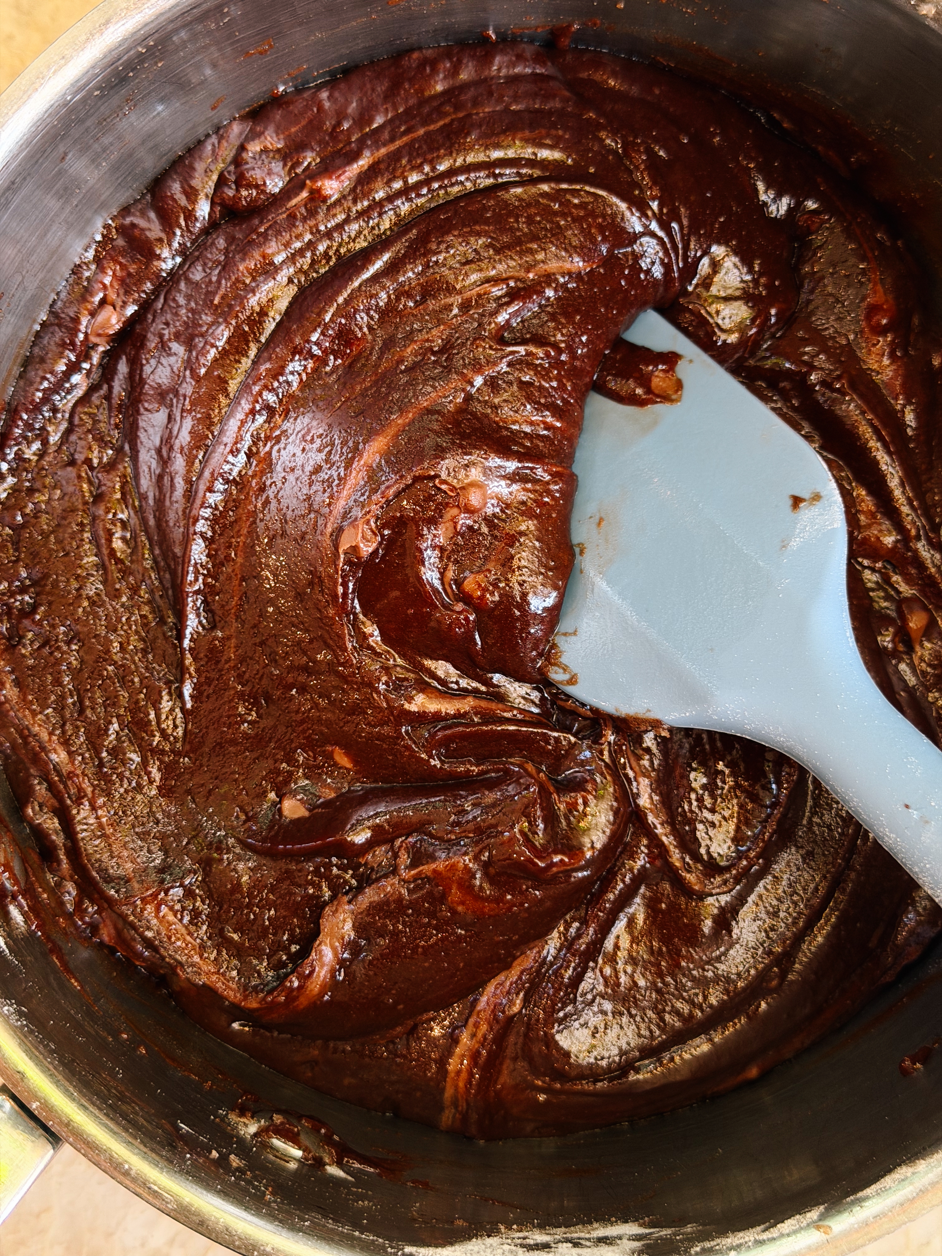 Thick brownie batter being mixed in a bowl with a spatula