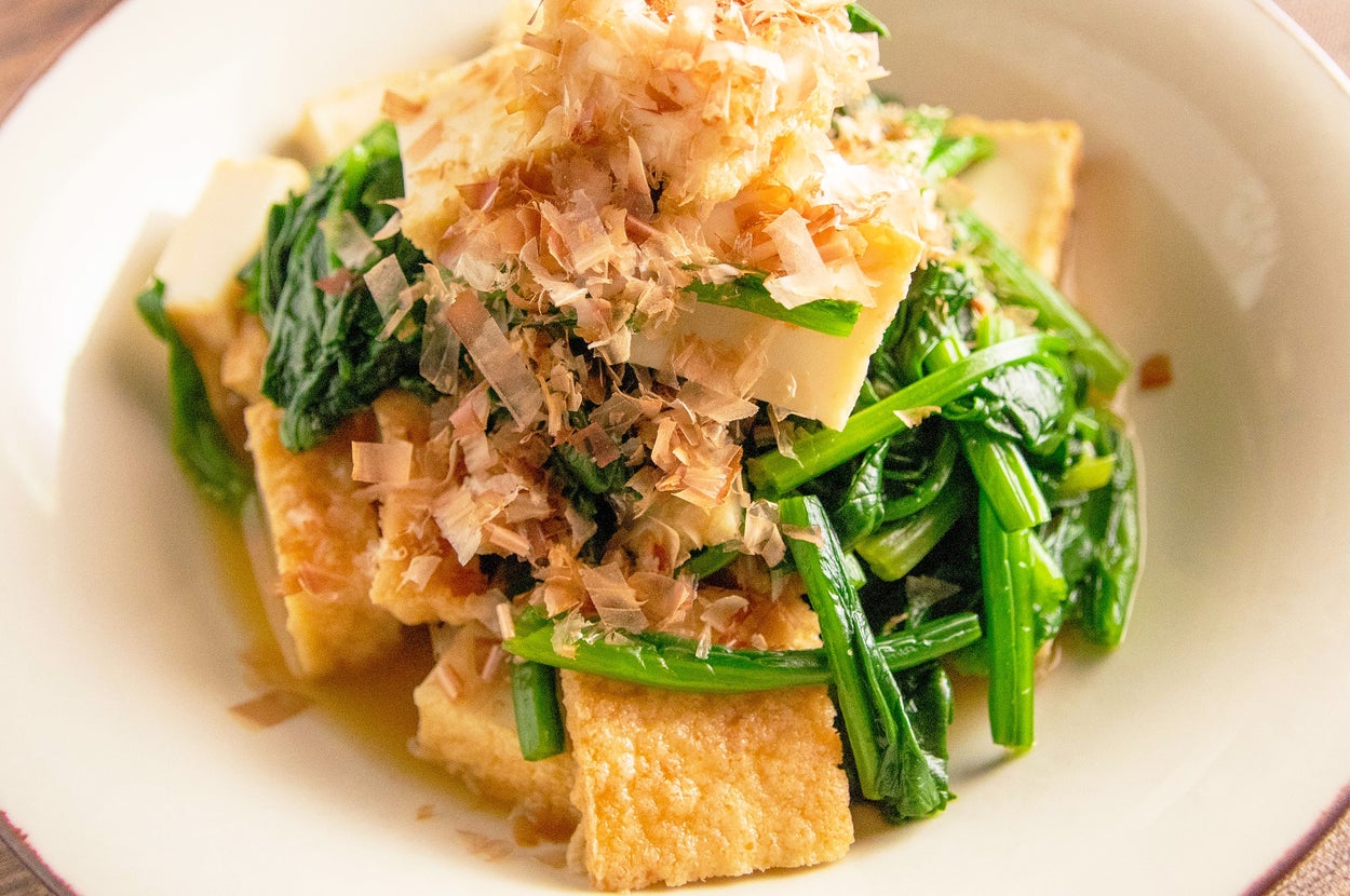 お皿に盛られた厚揚げとほうれん草の和風サラダ。上に削り節がのっている。