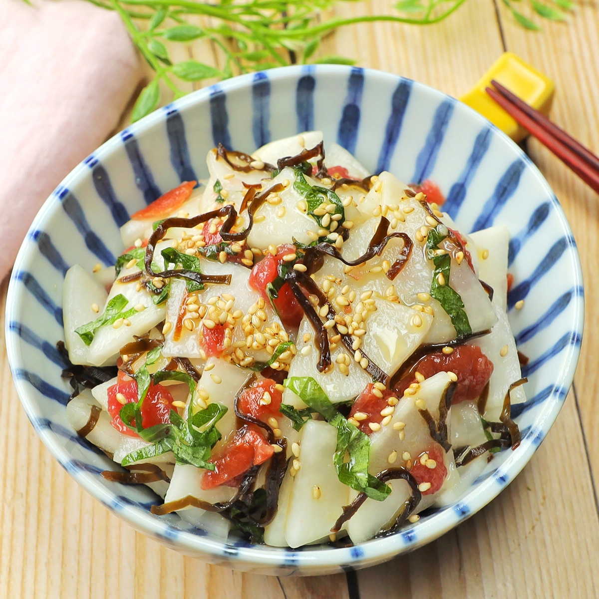 和風のサラダ、レンコンと昆布が盛り付けられたボウル。ゴマがトッピングされ、美しく飾られている。