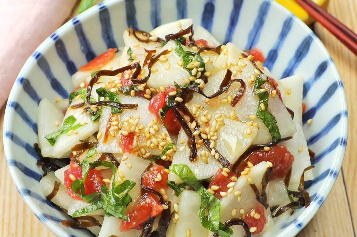 和風のサラダ、レンコンと昆布が盛り付けられたボウル。ゴマがトッピングされ、美しく飾られている。