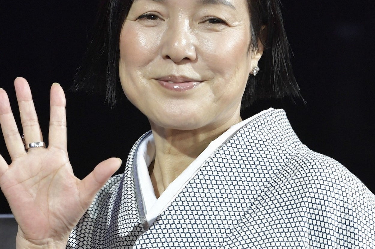 着物を着た女性がカメラに向かって手を振っている様子。