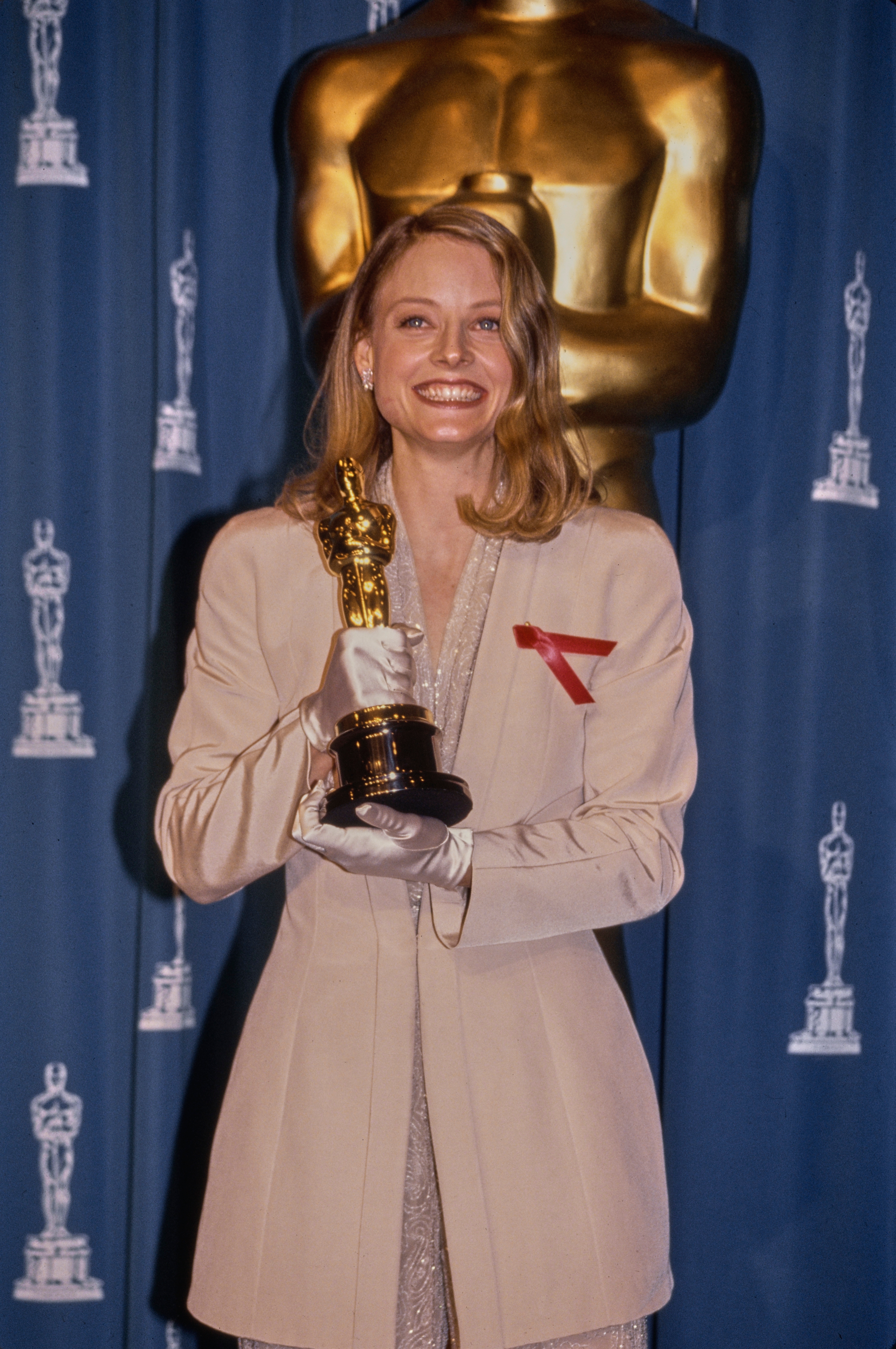 Person successful  a ceremonial  suit   holding an award, lasting  successful  beforehand   of an Oscar statue